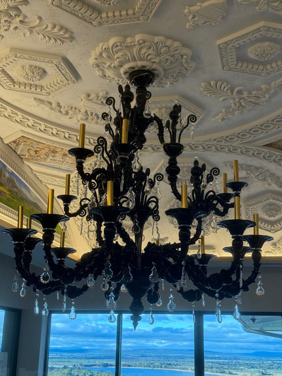 Large black crystal chandelier under an ornate ceiling